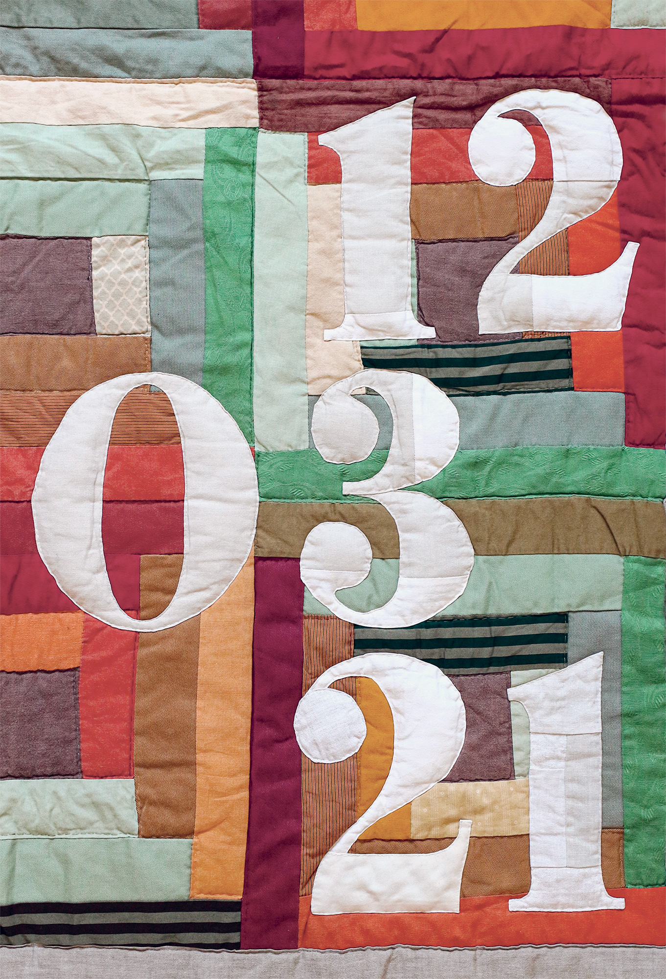 Detail of orange and green patchwork with birth date appliqué – Pénélope Westberg studio creation
